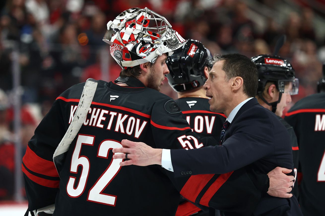 Pyotr Kochetkov #52 and head coach Rod Brind’amour of the Carolina Hurricanes hug after their 5-4 series clinching double overtime win against the New Jersey Devils in Game Five of the First Round of the 2025 Stanley Cup Playoffs at Lenovo Center on April 29, 2025 in Raleigh, North Carolina.