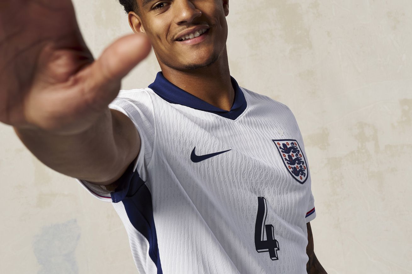 Jarrell Quansah pictured smiling with his arm raised toward the camera for England U21’s promotional images.
