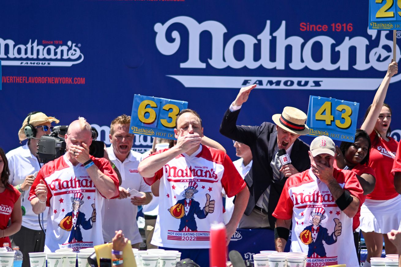 Defending Champion Joey Chestnut competes in the 2022 Nathans Famous Fourth of July International Hot Dog Eating Contest at Coney Island on July 04, 2022 in the Brooklyn Borough of New York City. Chestnut consumed 63 hot dogs. The contest, which has happened every year since 1972, was back in front of Nathan’s Famous on Surf Avenue this year.